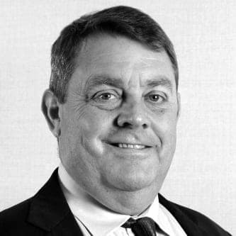 A black and white photo of a man in a suit and tie