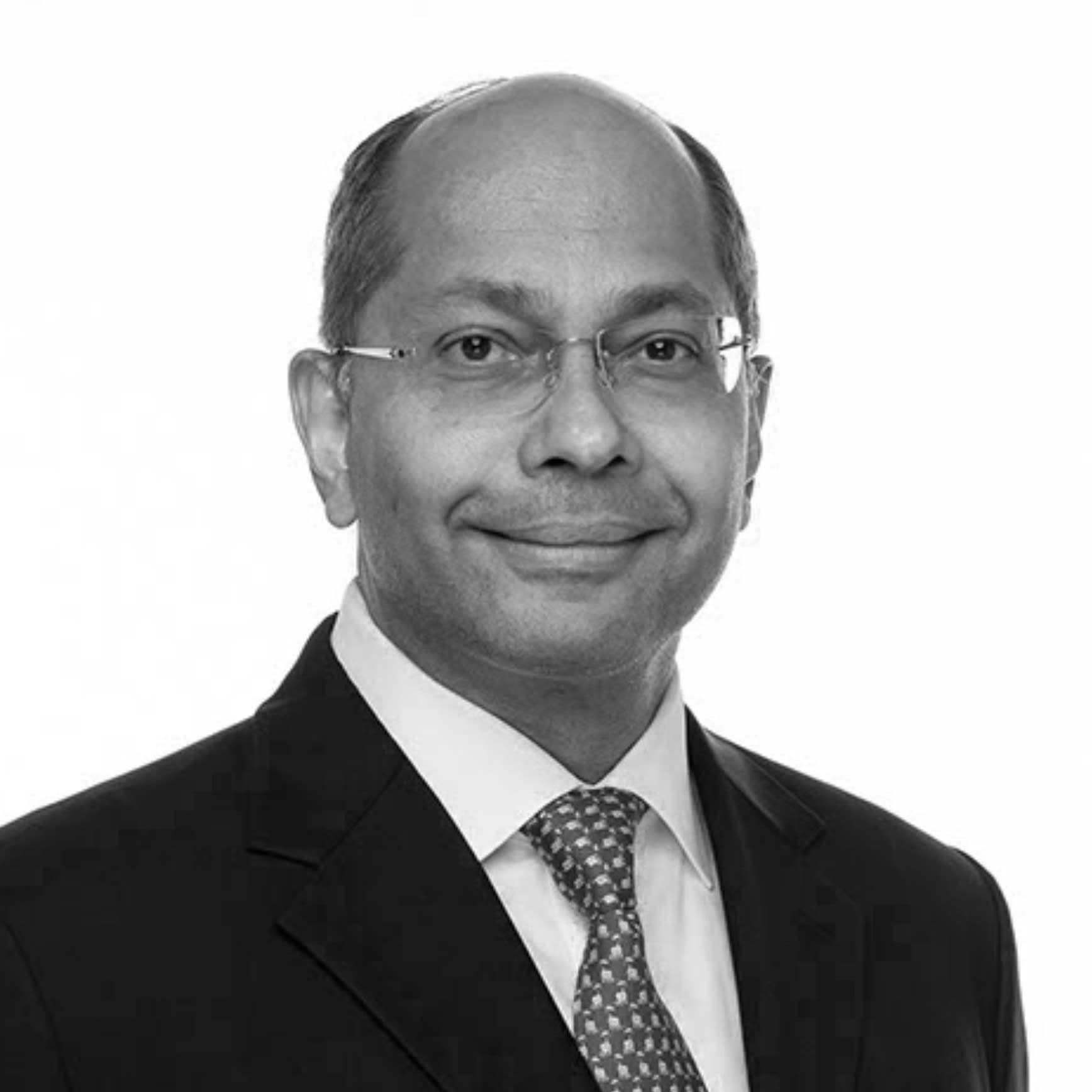 A black and white photo of a man in a suit and tie